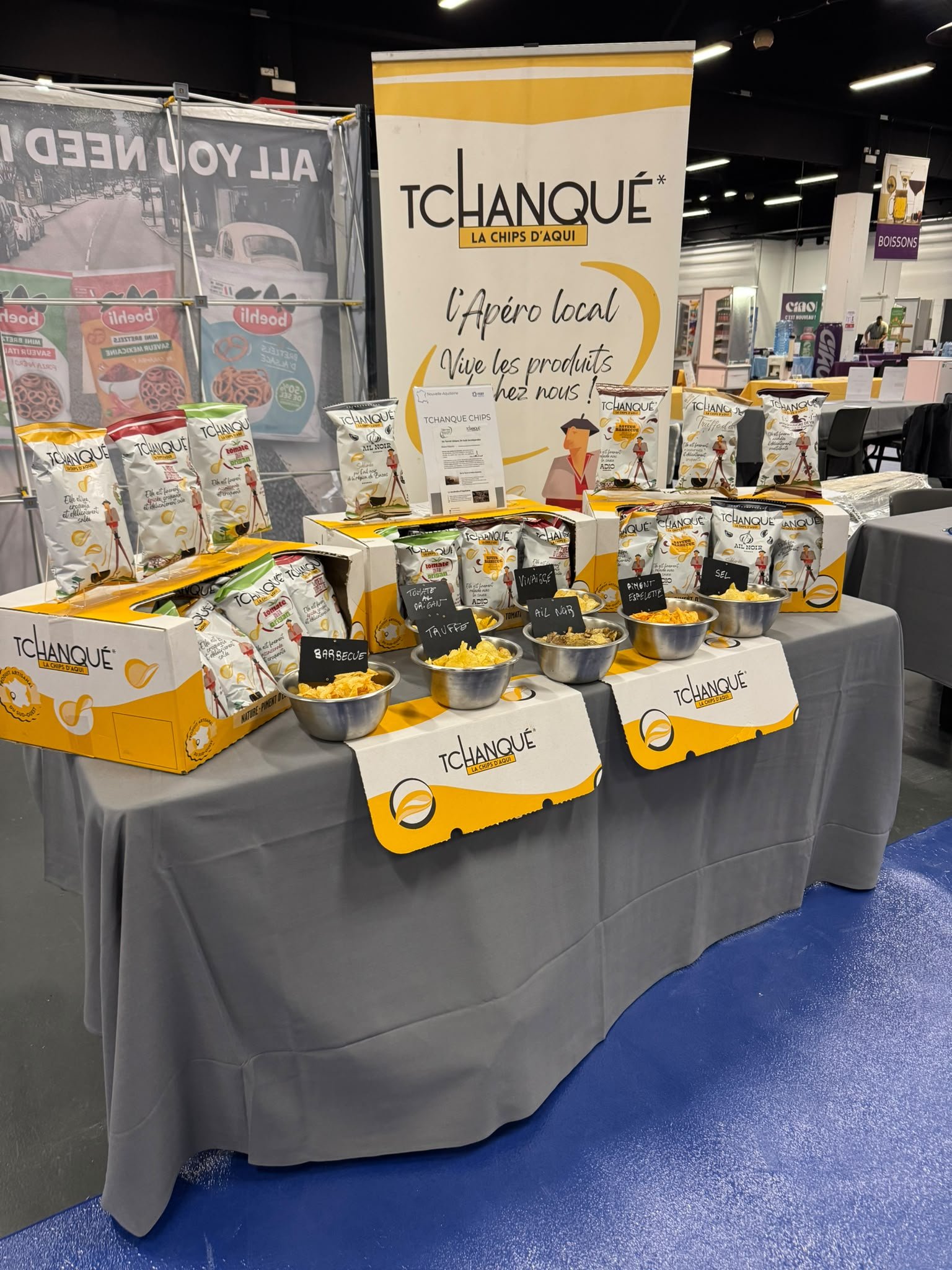 Présentation des chips Tchanqué sur un stand de salon, avec la gamme et les bols de dégustation.